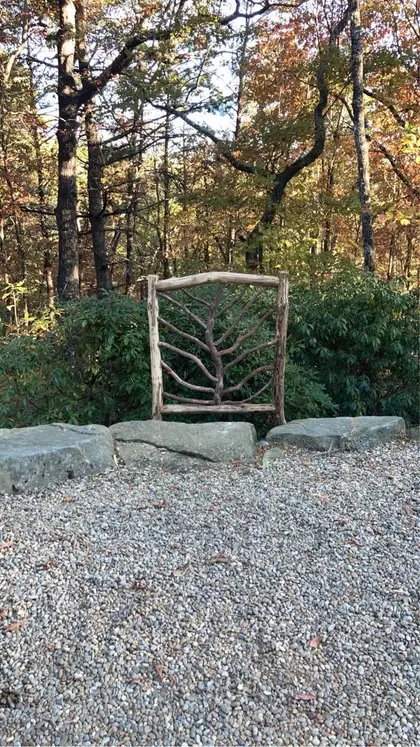A pair of locust gates with hand-fitted rails leaning against a stone wall